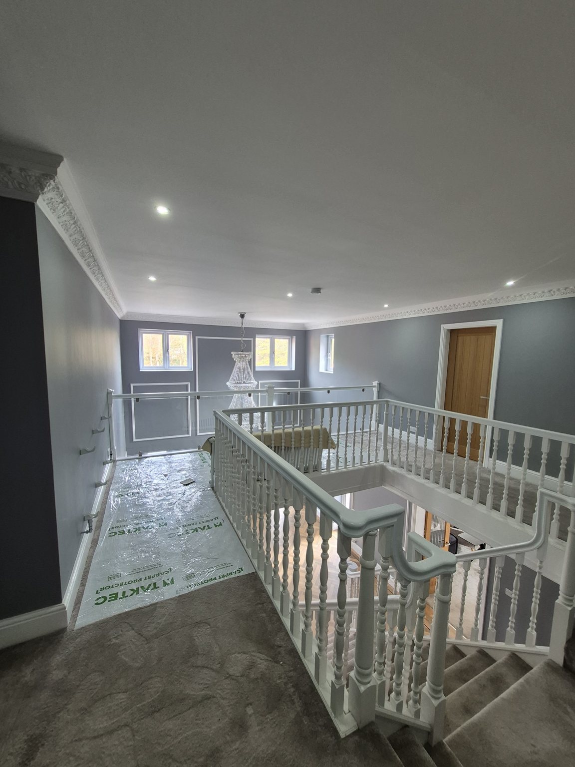 Bright landing with white balustrade and coving after decorating